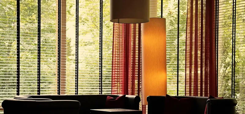 Wooden venetian blinds across floor-to-ceiling windows
